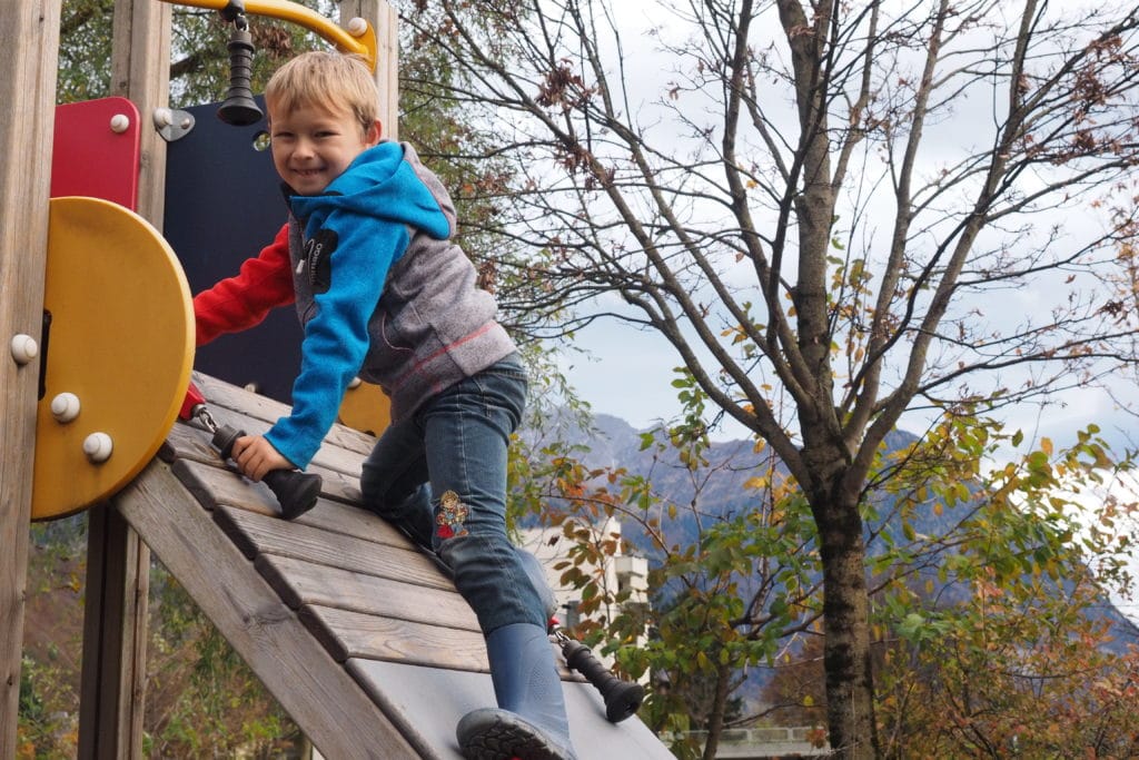 Kind beim Klettern auf einem Spielgerüst.