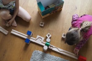Kinder spielen mit Kugelbahn