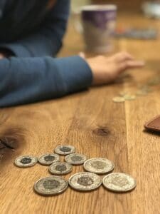 Junge beim Geld zählen mit Schweizer Franken Münzen