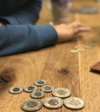 Junge beim Geld zählen mit Schweizer Franken Münzen