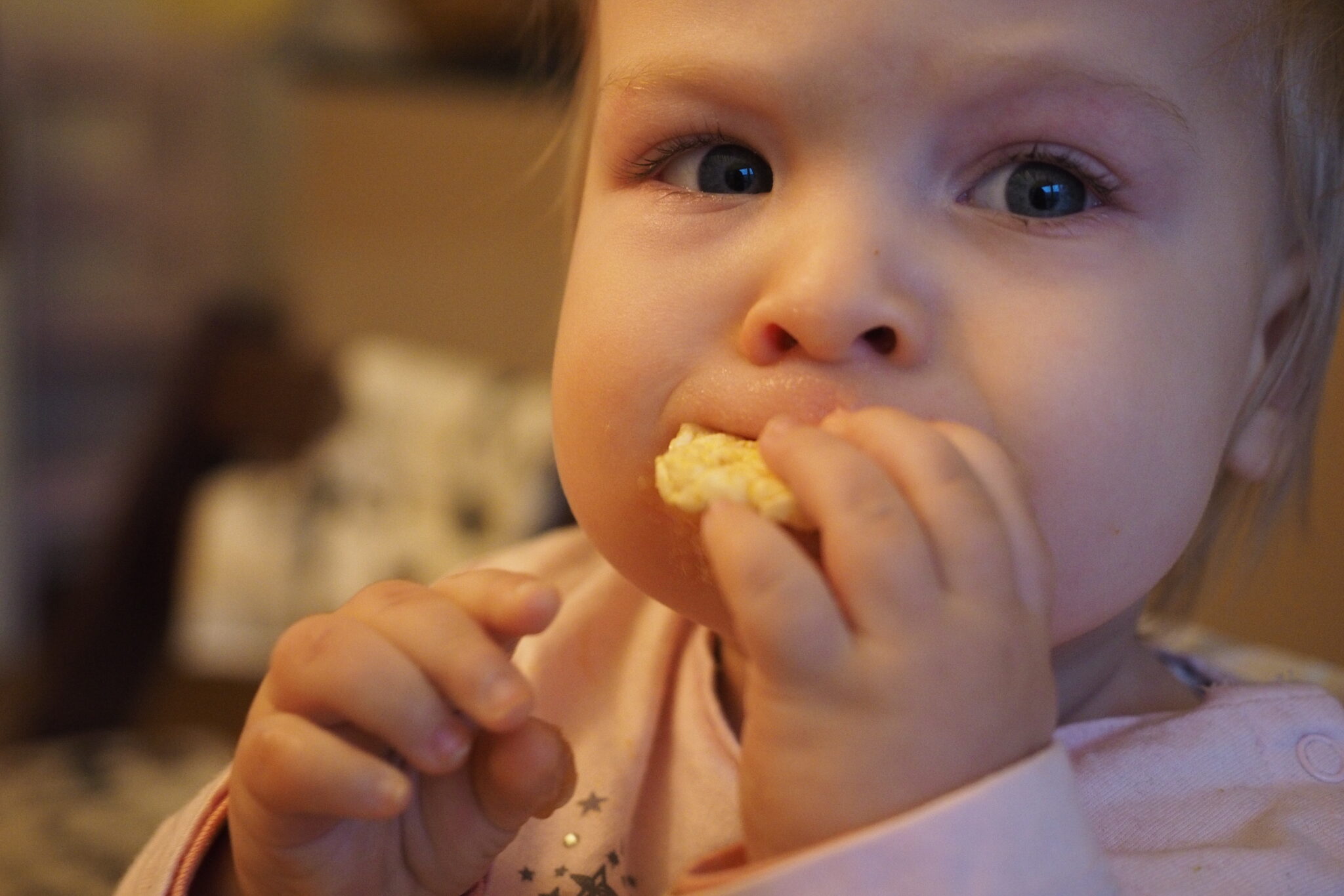 Kleinkind isst Reiswaffel am Tisch