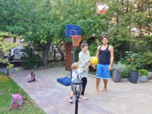 Familie spielt Basketball auf dem Hof