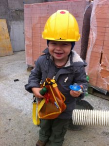 Kind mit Helm auf Baustelle