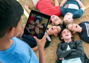 Kind macht Foto von anderen Kindern auf dem iPad