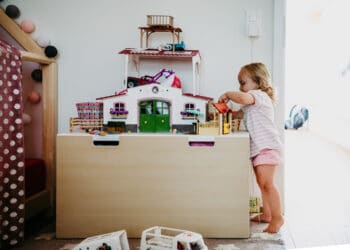 Mädchen spielt mit Pferdestall von Schleich