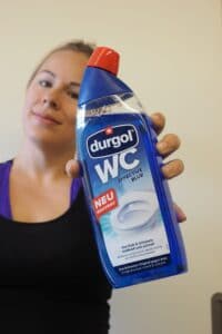 Frau hält WC-Reiniger durgol effective blue